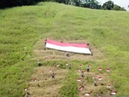 Polres Wondama, Papua Barat, membentangkan bendera merah putih berukuran besar di puncak gunung alang-alang Wasior menyambut HUT Ke-76 Kemerdekaan RI. (Foto: Antara )