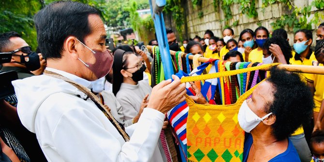 Presiden Jokowi beli tas noken dari mama Papua yang berjualan di pinggir jalan.