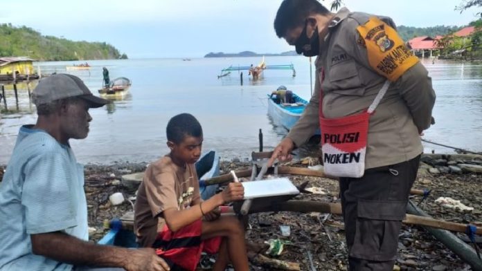 Aipda Desri Kendek tengah mengajar baca tulis di Kampung Waiya, Depapre, Kabupaten Jayapura. (Foto: Dok/Humas Polda Papua)