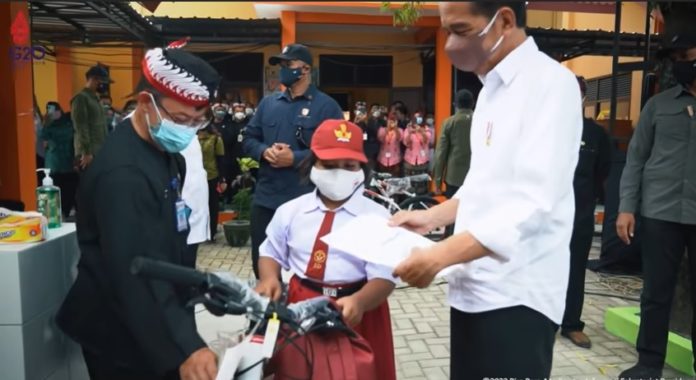 Presiden Jokowi saat memberikan sepeda kepada Nana.